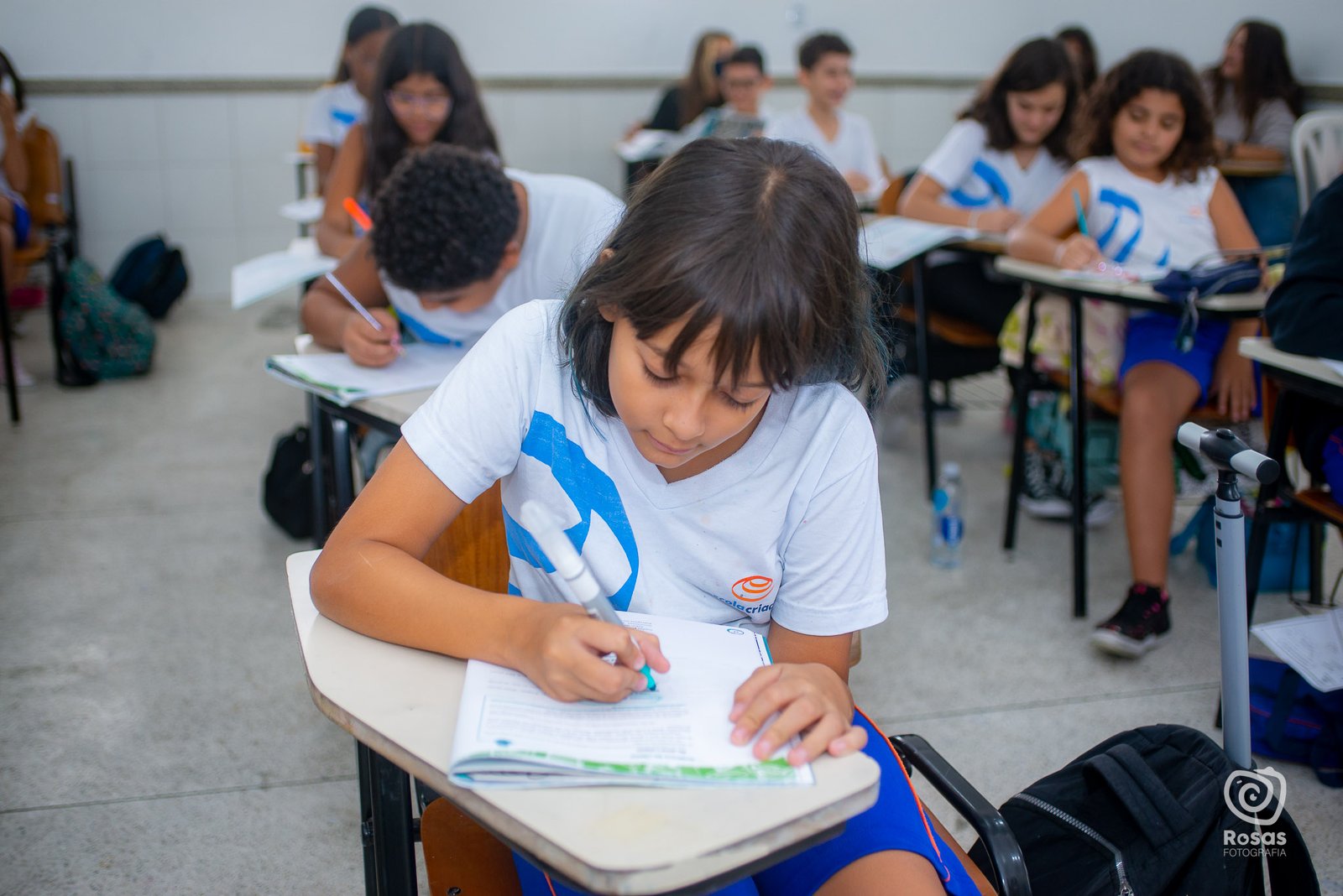 Aluna do Ensino Fundamental escrevendo durante a aula