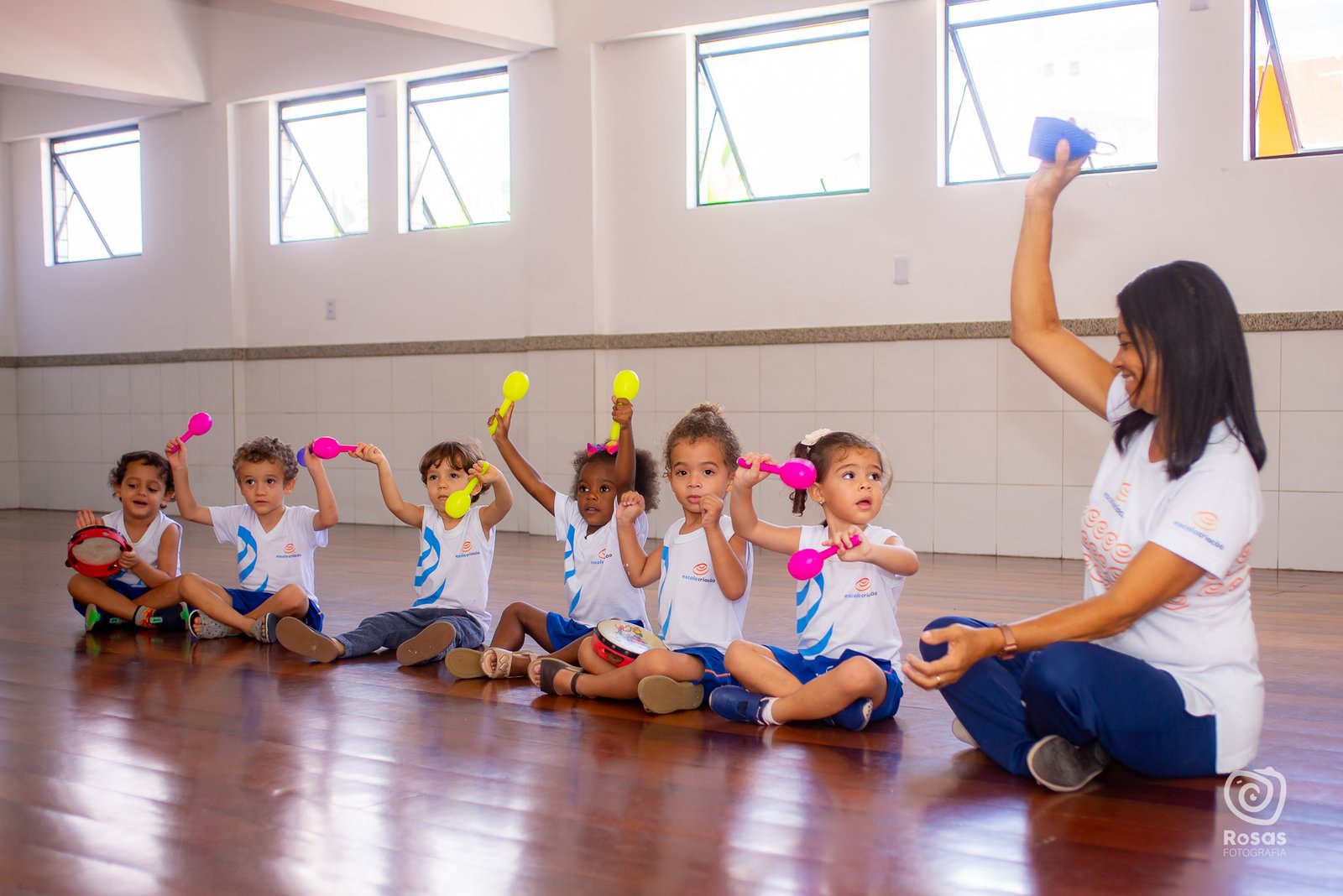 Professora e crianças da Educação Infantil em roda de atividades no salão