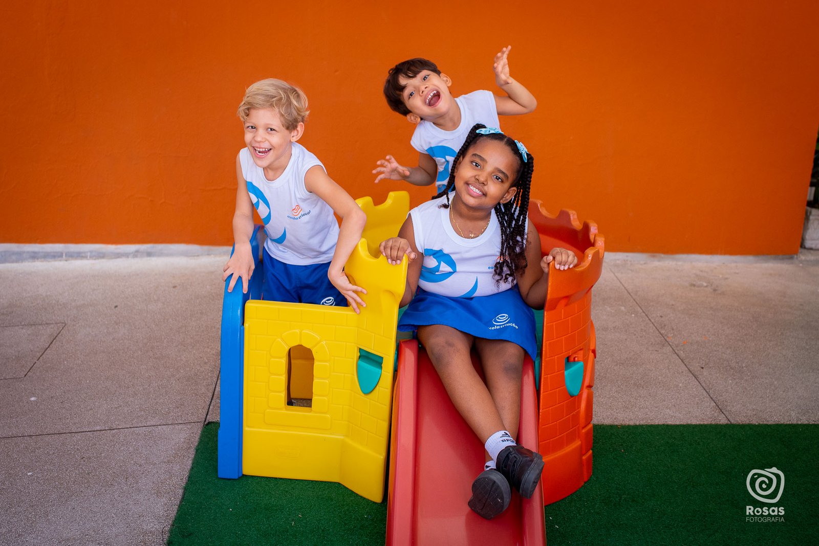 Crianças da Educação Infantil brincando no escorregador do parque da escola