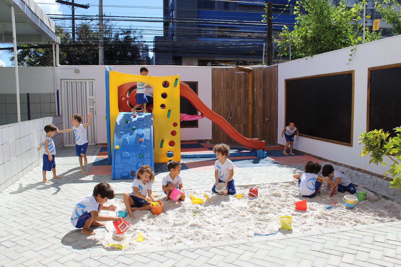Crianças brincando no tanque de areia do parque infantil