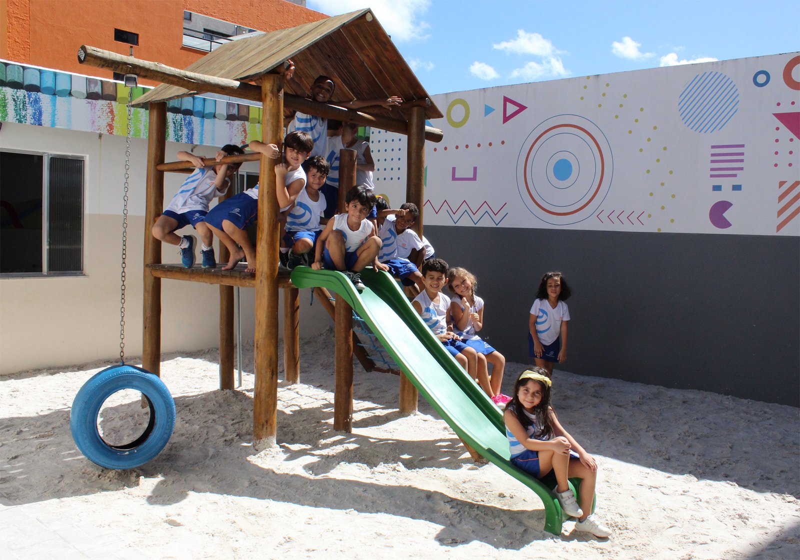 Crianças brincando no parque de madeira da escola
